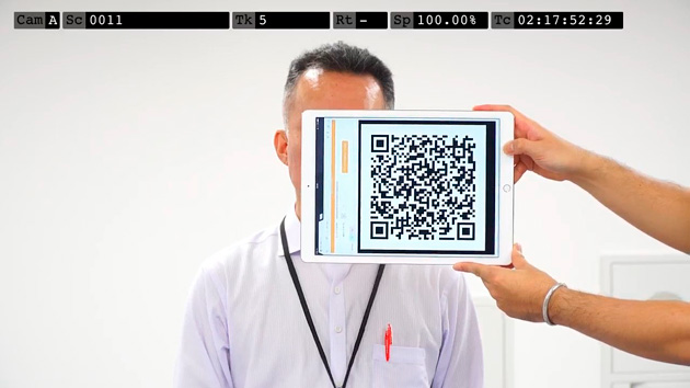 撮影開始の様子。「カチンコ」のようにQRコードを映す。 QRコードには、撮影シーンやカット番号などの情報が入っており、撮影動画をシステムにアップロードした際にQRコードが自動で識別され、仕分けがされる。